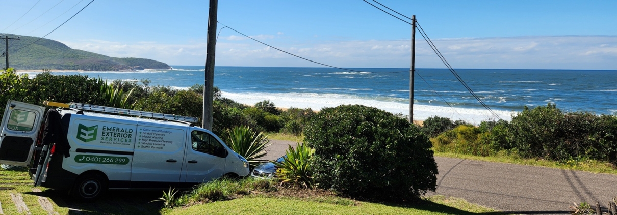 Emerald Exterior Services van in beachfront property driveway.
